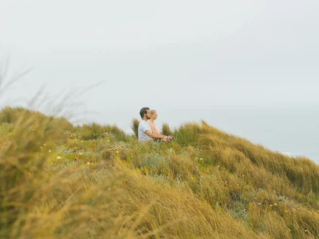 Meditation among soft coastal grasses at the 4elements retreat in Portugal